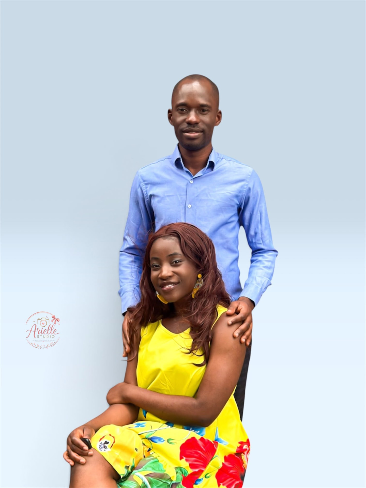 Tunde standing behind Busolami, seated in a yellow floral dress